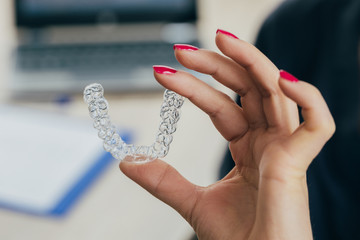 Doctor hand holding a clear dental aligner