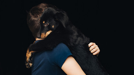 Studio shot of young man holding puppy