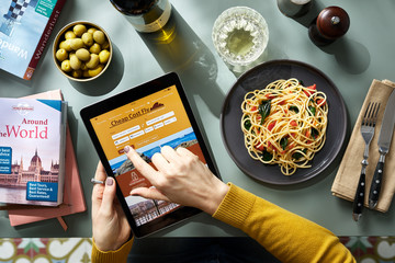 Woman checking flight tickets on a website at lunch.