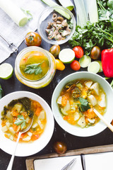 Minestrone recipe, tasting and writing rcipe on cook book about italian minestrone soup, on bowl and jar with cherry tomato brown, lime, and link round pieces, with a blank diary to write and add text