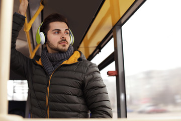 Fototapeta na wymiar Young man listening to music with headphones in public transport