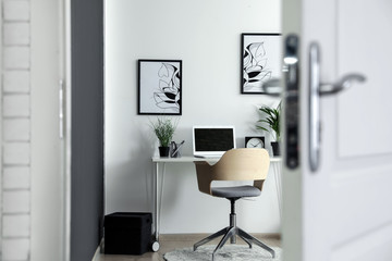 Stylish home office interior, view through open door