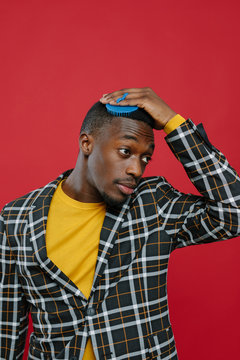 Stylish ethnic man combing hair