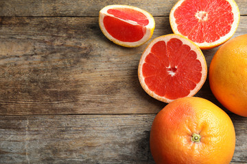 Fototapeta na wymiar Fresh tasty grapefruits on wooden background, top view with space for text