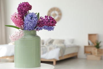 Fototapeta na wymiar Beautiful hyacinths in metal can on table indoors, space for text. Spring flowers