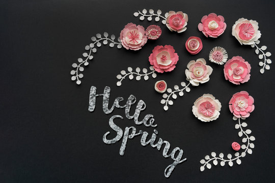 Paper flowers with Hello Spring text written with chalk