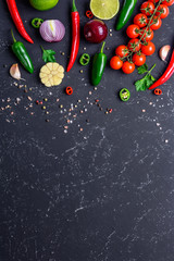 Concept of cooking healthy vegan food. Selected vegetables, fruits, spices, herbs for making various sauces on a black stone table. Top view with copy space.