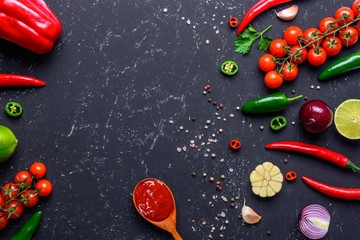 Traditional mexican salsa sauce and ingredients on dark stone background. Tomato sauce. Top view with copy space.