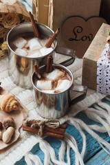 Fototapeta na wymiar Metal mugs with cacao and marshmallows