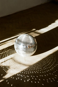 Disco-ball on a floor in sunny room
