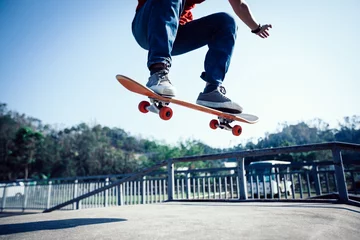 Tuinposter Skateboarder skateboarding at skatepark ramp © lzf