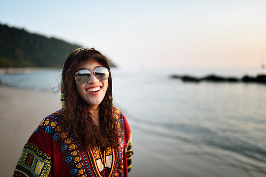 Fashionable Thai woman with permed hair on a tropical beach at dusk
