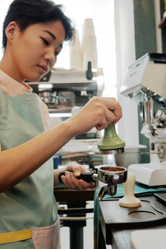 Barista tamping coffee