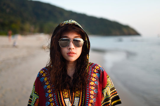 Fashionable Thai woman with permed hair on a tropical beach at dusk