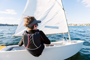 Teenage boy sailing a small dinghy