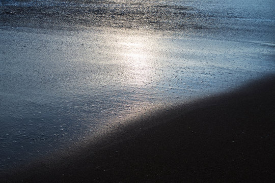 sun reflecting in shallow water at the beach