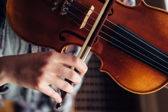 Girl's hand playing her violin from overhead