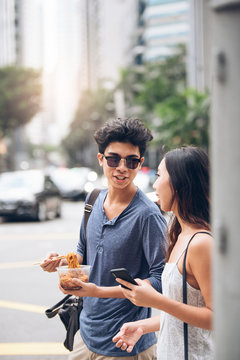 Smiling couple chatting and having fun in the street.