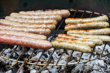 Multiple tasty sausages on the grill in close up