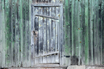 wooden old green door on a rustic barn