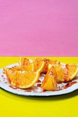 Orange slices with chilli powder and chamoy on colorful background