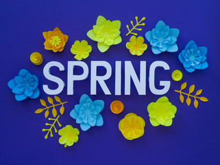 Spring hand lettering card. Spring tulip narcissus, plumeria paper flowers on dark blue background.