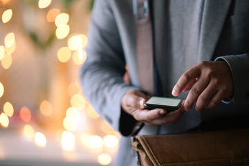 Man using his cellphone in walking street and  bokeh lights