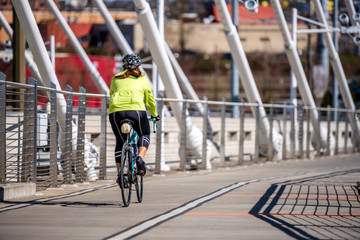 Woman in sportswear and helmet rides bicycle taking care of her health