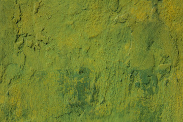 old shabby green yellow blue wall with scratches, cracks and stains of paint. rough surface texture