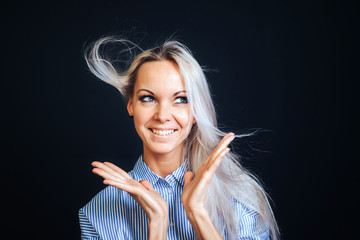 An attractive girl with developing hair spread her hands and smiles widely.