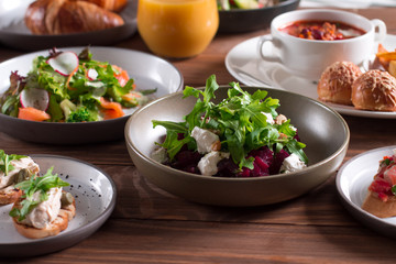 beetroot salad with blue cheese, arugula and walnut in a plate on a wooden background