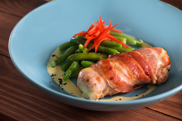 Fried chicken roll wrapped in bacon, fried, with green beans and paprika