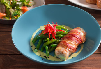Fried chicken roll wrapped in bacon, fried, with green beans and paprika