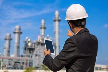 businessman is use smartphone check system at gas turbine electric power plant