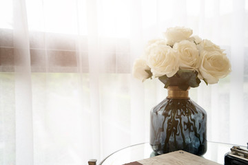 beautiful white roses flower vase with sofe living room home interior background