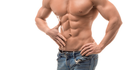 Fototapeta premium Male torso with perfect abs. Man in blue jeans touching his abs isolated on white.