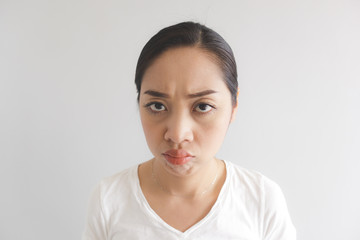 Sulk and grumpy face expression of woman in white t-shirt. Concept of offended peevish and sulky.