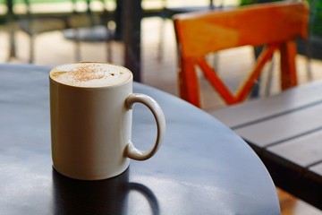 a cup of coffee in the morning, hot coffee in a white mug isolate on a black table,  Hot cappuccino sprinkle with cinnamon powder, charge me up for long day, 