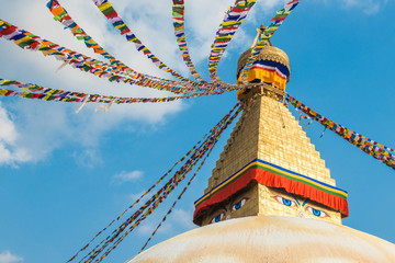 The Buddhist prayer flags flowing in the wind by hanging on the tiered of Boudhanath Stupa the...