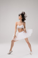 Fototapeta premium Attractive woman dancing in ballet skirt and gumshoes 
