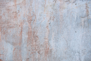 Texture of an old wall. A fragment of a concrete surface with natural damage. Red and grey palette of shades.