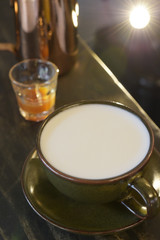 close up of glass cup with fresh milk on wooden table