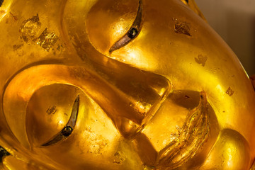 Close-up face of sleeping Buddha statue from a temple in Chiang Mai, Thailand