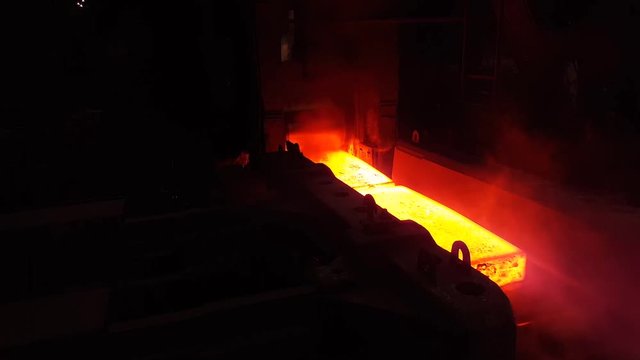 Two ingots of hot metal are rolled in a slab mill.