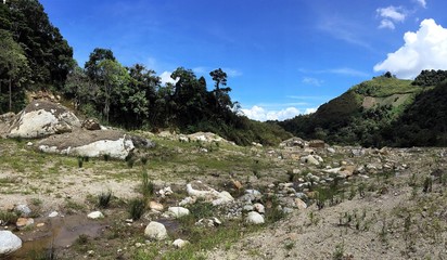 Trail in the mountain full of rocks on a shiny clear blue sky day.