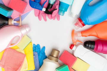 Cleaning equipment on light background. Bottles with detergent and cleaning tools. Colorful...