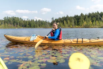 Foto op Canvas a woman heartily enjoys kayaking with a broad smile © Fabian