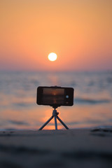 A mobile iphone camera in a tripod of beach location 