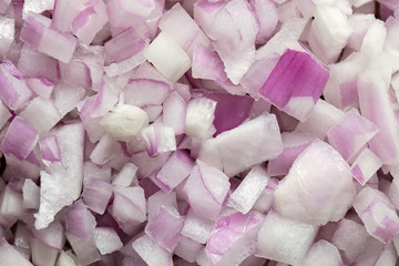 Chopped red onions on wooden cutting board, closr up