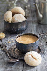 Metal Cup of coffee, pot and cookie on wooden rustic background as a still life vertical composition